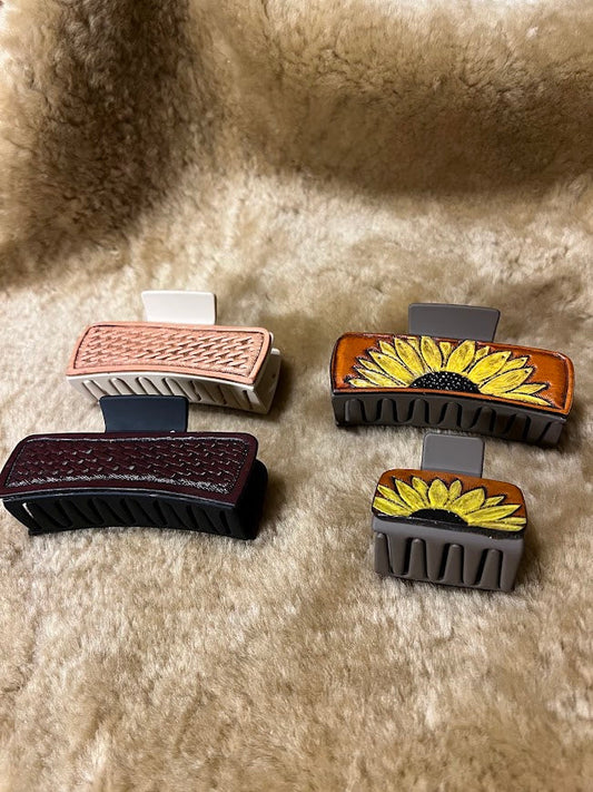 Custom hand-tooled leather hair clips in various styles including basketweave, sunflower, and geometric patterns