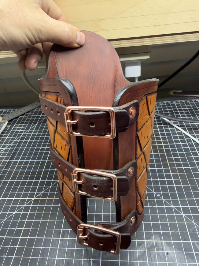 Interior view of the leather welder's arm guard showing construction and buckle hardware