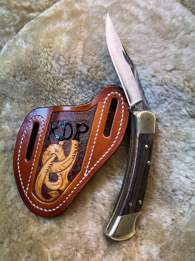 Custom floral carved pancake knife sheath with KDP initials and Buck knife